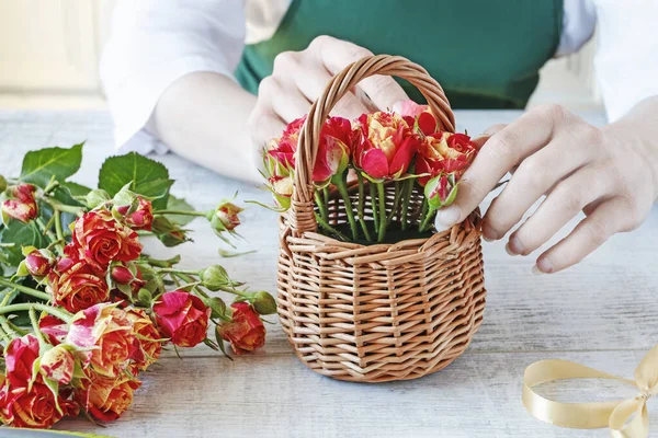 Woman shows how to make a floral arrangement with roses inside t — Stock Photo, Image