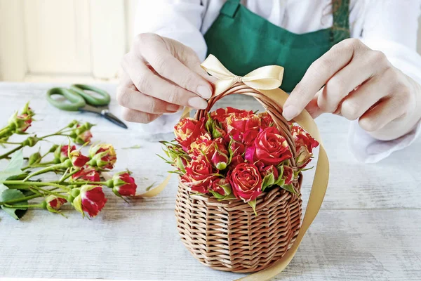 Женщина показывает, как сделать цветочную композицию с розами внутри т — стоковое фото