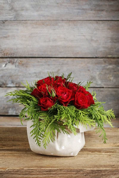 Donna mostra come fare una disposizione floreale con rose rosse e — Foto Stock