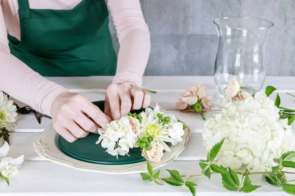 Vrouw toont hoe om te maken bruiloft tafel decoratie met krans en — Stockfoto