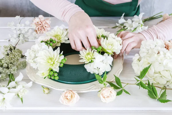女性はリースと結婚式のテーブルの装飾を作る方法を示しています — ストック写真