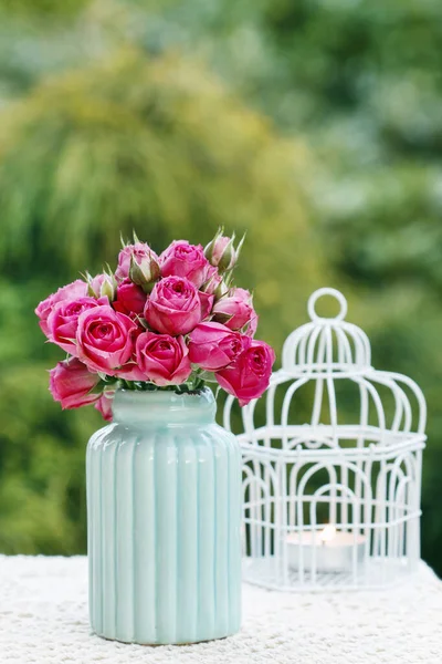 Blomsterarrangemang med rosa rosor och romantiska lyktor. — Stockfoto