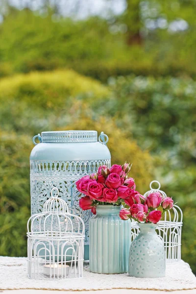 Arrangement de table florale avec des roses roses et des lanternes romantiques . — Photo