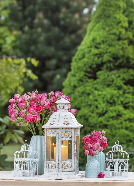 Arrangement de table florale avec des roses roses et des lanternes romantiques . — Photo