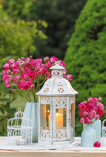 Arreglo de mesa floral con rosas rosadas y linternas románticas . — Foto de Stock