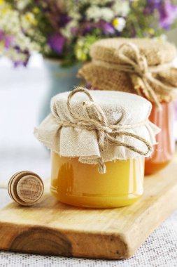 Ballı kavanozlar ve bahçede bir buket yabani çiçek. 