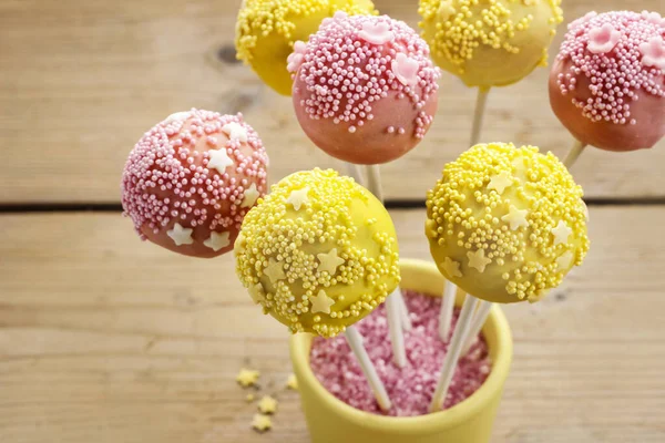 Pink and yellow cake pops.