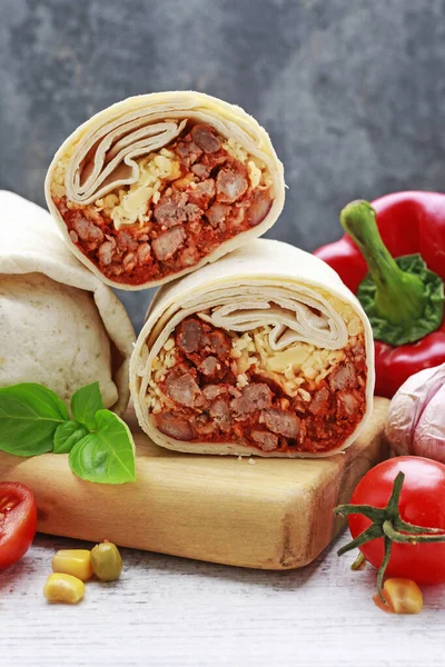 Burrito-meksykańskie danie, które składa się z tortilla mąki z — Zdjęcie stockowe