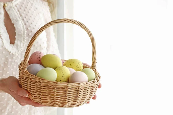 Woman holds a wicker basket with Easter eggs — Stock Photo, Image