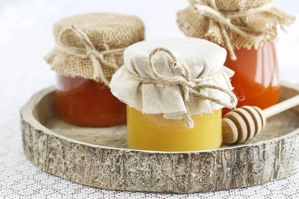 Glasburkar med honung på bordet. — Stockfoto