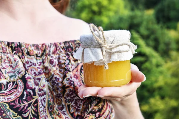 Woman holding glass jars of honey. — Stock Photo, Image