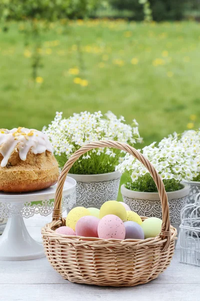 Cesta de mimbre con huevos de Pascua en el jardín . — Foto de Stock