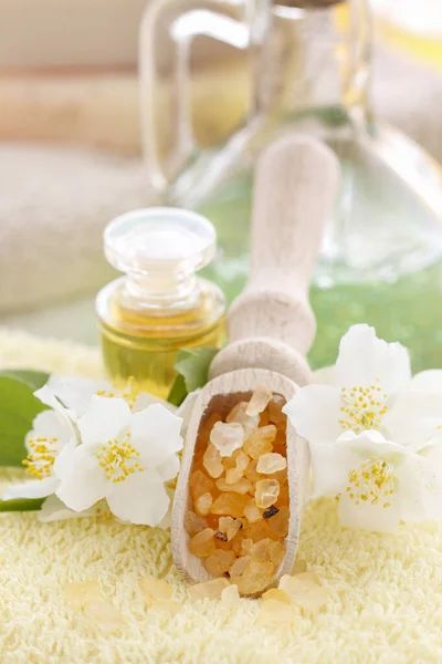 Lepel met geel zeezout tussen witte jasmijnbloemen. — Stockfoto