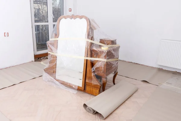 Furniture wrapped in foil to avoid damage during renovation of the room. The interior is ready for painting.