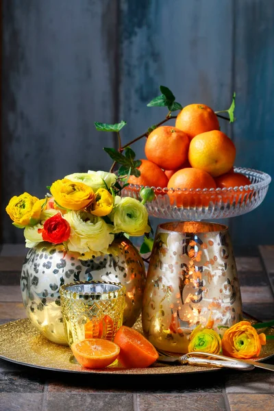 Hahnenfuß Einer Goldenen Vase Und Einem Haufen Süßer Orangen Tischdekoration — Stockfoto