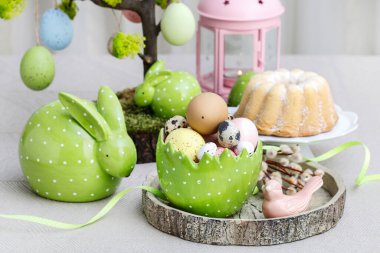 Boyanmış yumurta ve seramik heykelciklerle Paskalya masa süslemeleri. Şenlik zamanı