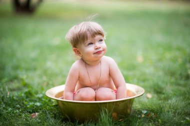 Bebek su havzasına mutlu bir şekilde oturur.