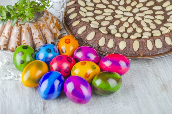 colorful easter eggs and easter cake on wooden table