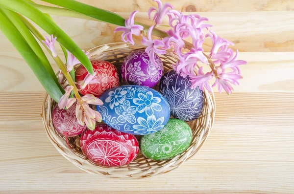 木桌上五颜六色的复活节彩蛋和粉红色的风信子花 — 图库照片