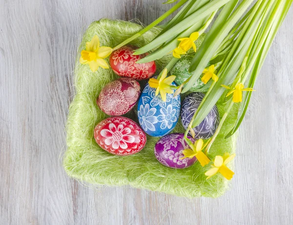 Bunte Ostereier Und Narzissenblumen Auf Holztisch — Stockfoto