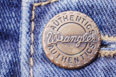 Mavi kot üzerinde Wrangler düğmesinin closeup. Wrangler, Amerikalı kot pantolon üreticisidir. Merkezi Greensboro, North Carolina, ABD'de.