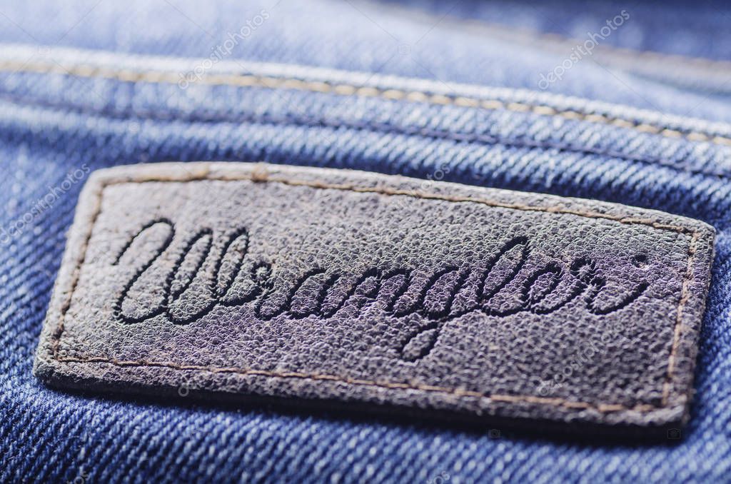 Closeup of Wrangler label on blue jeans. Wrangler is American manufacturer of jeans. Its headquarters is in Greensboro, North Carolina, USA