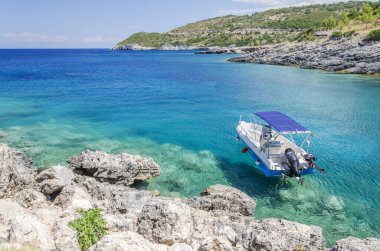 Resimli turkuaz Stoufis plajındaki sürat teknesi. Yunanistan 'ın Zakynthos adasının kuzey doğu kıyısında yer almaktadır..