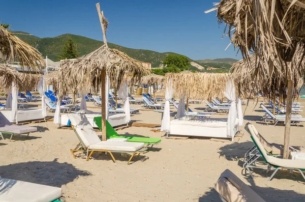 希腊Zakynthos岛东海岸沙滩上的草滩遮阳伞和太阳椅 — 图库照片
