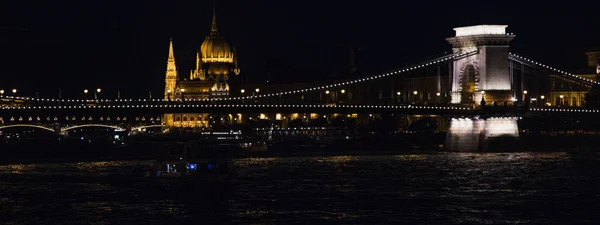 view of bridge and Budapest Parliament lighting at nighttime