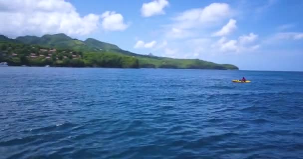 Luchtfoto van de Drone van een kayaker peddelen in de buurt van een tropisch paradijs strand omgeven door zee en jungle in het Caribische eiland St. Lucia — Stockvideo