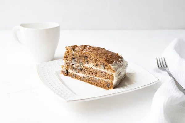 Slice of carrot cake and coffee on white background