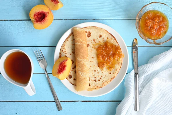 Große Pfannkuchen Mit Marmelade Tee Und Pfirsichen Auf Blauem Hintergrund — Stockfoto