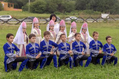 Maikop Adigeia Bölgesi,Rusya Federasyonu 08.27.2016 : Doğada etnik festivalinde ulusal kostümler içinde dans eden çocuklar.