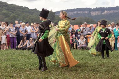 Maikop Adigeia Bölgesi,Rusya Federasyonu 08.27.2016 : Doğada etnik festivalinde ulusal kostümler içinde dans eden çocuklar.