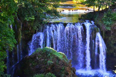 O önde rock ile şelale. Yaz, yeşil orman ve çevresinde moss. Köy, Mirjana Rastoke, Hırvatistan.