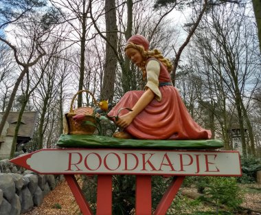 Kaatsheuvel / Hollanda - 29 Mart 2018: kırmızı kız yolda tema parkı Efteling imzalamak. Bahar.
