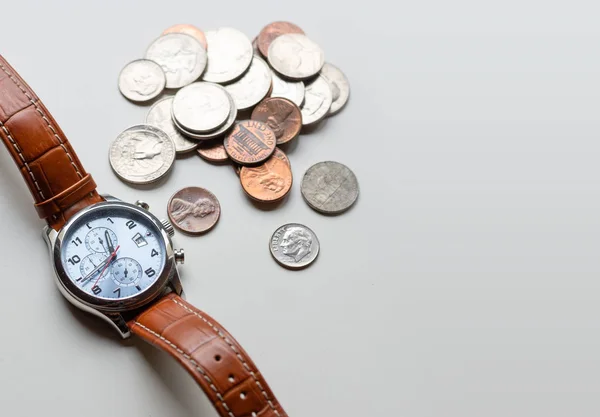 Zaman ve para arasındaki ilişki hakkında bir kavram. Bir saat ve bozuk paralar. - görüntü — Stok fotoğraf