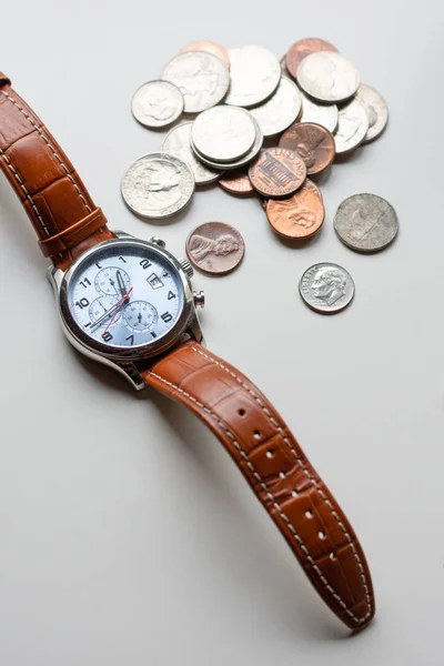 Time is money, time value of money concept : Coins and vintage brass pocket watch, idea of time which is a valuable commodity or resource and it's better to do work or things as quickly as possible. -