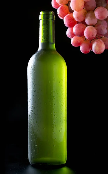 Nagyon hideg fehér borosüveg egy csomó vörös szőlő fekete háttér - kép — Stock Fotó