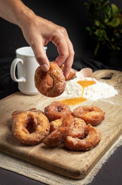 El yapımı bir çöreği hazırlamak için malzemelerle dolu bir masada tutuyor.