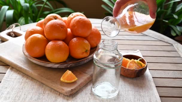 Jugo Naranja Recién Exprimido Vertiendo Recipiente Vidrio Con Naranjas Fondo — Vídeos de Stock