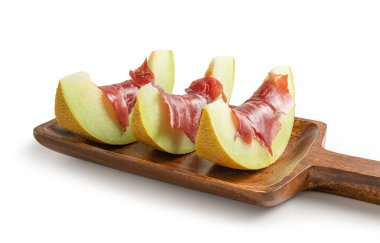 Beyaz arka plandan izole edilmiş, ahşap servis tahtasında kurutulmuş jambonlu kavun dilimleri.