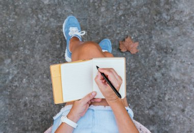 Not defterine not alan kadın, üst görünüm