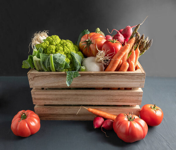 wooden box with fresh vegetables, rustic background