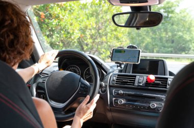 Arabanın içindeki kadın GPS sinyallerini takip ediyor.