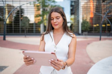İş kadını şehir ortamında tablet kullanıyor, dijital aygıt tutuyor, internette geziniyor