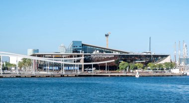 Barcelona, İspanya 15.09.2025, Barcelona 'daki Maremagnum alışveriş merkezinin modern mimarisi sakin mavi suyu yansıtıyor.