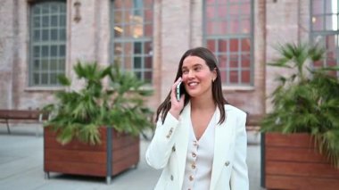 Businesswoman wearing white suit having phone conversation