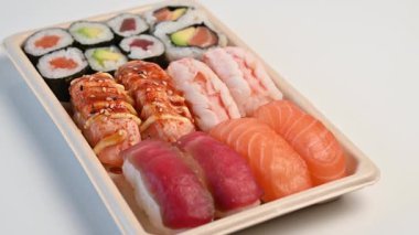 Lezzetli geleneksel Japon yemek tabağı servis ya da paket servis için beyaz bir zemin üzerinde dönüyor.