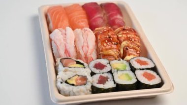 Lezzetli geleneksel Japon yemek tabağı servis ya da paket servis için beyaz bir zemin üzerinde dönüyor.
